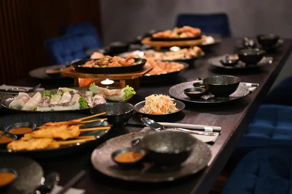 Ein gedeckter Tisch mit einer Vielzahl von verschiedenen Gerichten aus der asiatischen Küche.